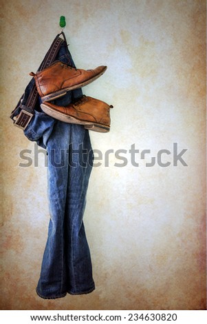 Jeans and boots hanging over grunge background
