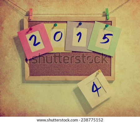 Vintage 2015 write on paper photo frame over wall background, New year concept