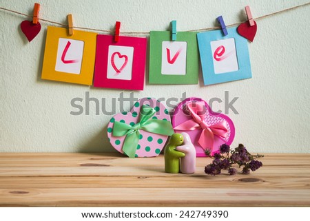 Vintage love write on paper paper photo frame on clothesline over grunge background, Valentine concept