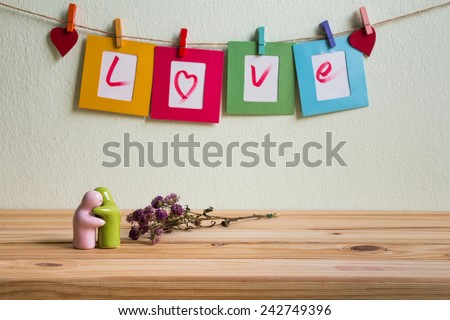Vintage love write on paper paper photo frame on clothesline over grunge background, Valentine concept