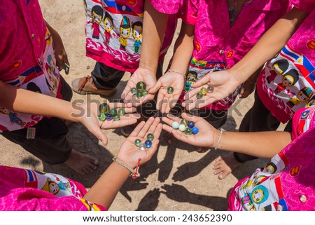 Children playing marbles, activity of student in Thailand.
