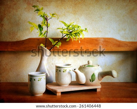 Still life with teacup on on wooden shelves over grunge background