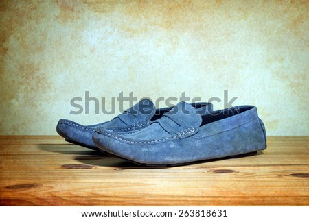 still life with Men's Casual Shoes on wooden table over grunge background