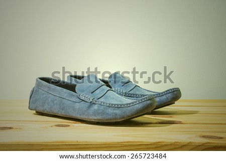 still life with Men\'s Casual Shoes on wooden table over grunge background