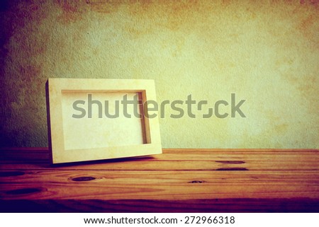 Vintage photo frame on wooden table over grunge background, Still life style