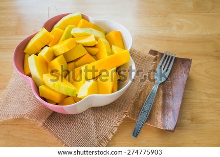 Slice of mango in bowl on dining table.