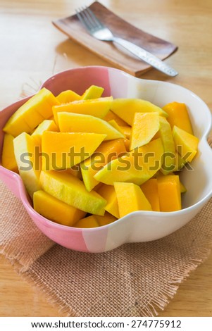 Slice of mango in bowl on dining table.