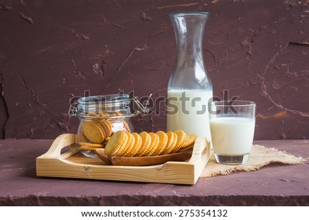 Milk with sandwich cracker on brown stone table over stone grunge background.