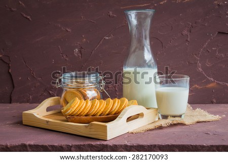 Milk with sandwich cracker on brown stone table over stone grunge background.