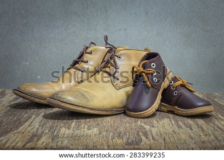 Daddy\'s boots and baby\'s shoes, fathers day concept.