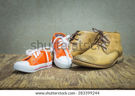 Daddy\'s boots and baby\'s sneakers, fathers day concept.