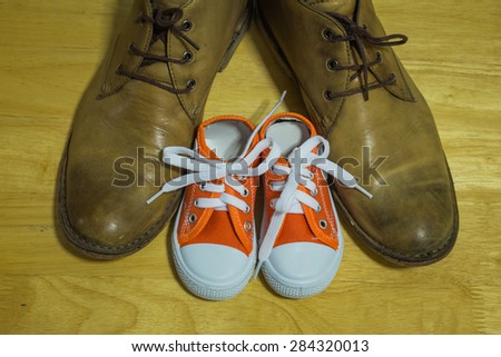 Daddy's boots and baby's sneakers, fathers day concept.