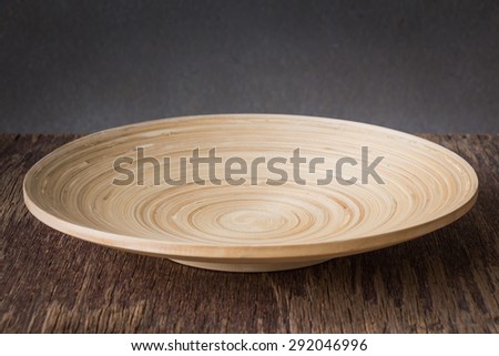 Wood plate on wooden table over grunge background, rustic style
