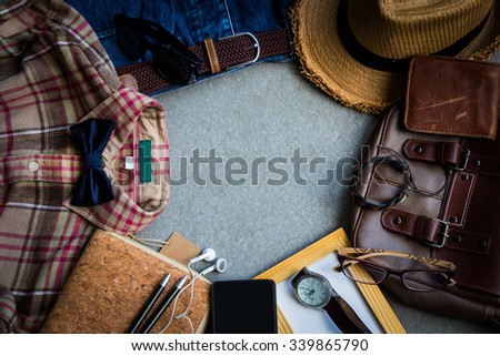 Men\'s casual outfits background, brown plaid shirt, bow tie, blue jeans, brown bag and stationary