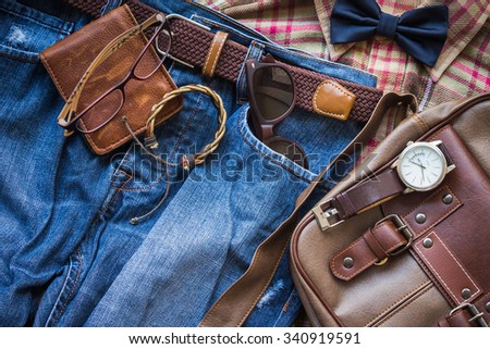 Men's casual outfits background, brown plaid shirt, bow tie, blue jeans, brown bag and stationary