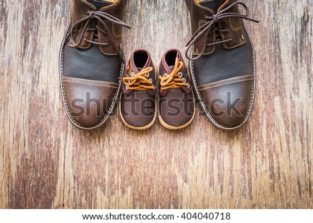 Father and son brown shoes on wooden background, fathers day