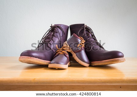 Brown shoes of daddy and son on on wooden table, bar or counter over white wall background, fathers day