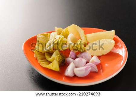 Side dishes on orange plate, pickled mustard green, Onoin sliced , lemon