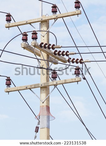of telephone utility poles, cables, streetlights, and clear blue sky background