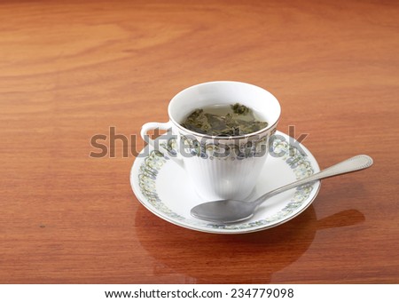 Oolong floating in a glass of hot water on the table in teak.