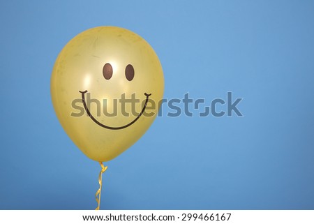 Yellow balloon with smile on blue background.Yellow Ribbon