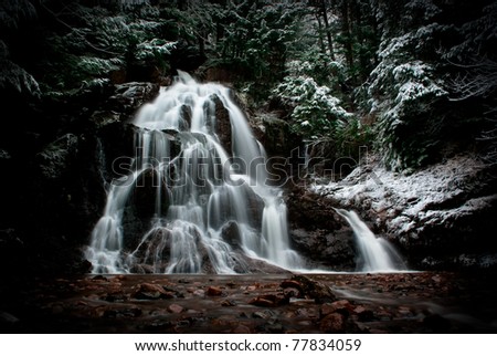 a cascading waterfall  showing multiple flows in a morning after a small snowfall.