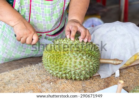 Vendor peeling Durian fruit for customer