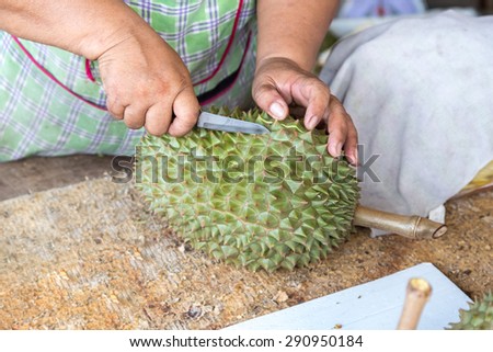 Vendor peeling Durian fruit for customer