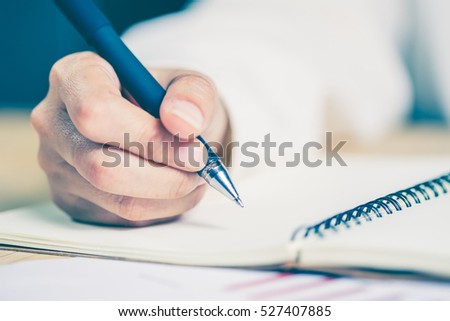Business women hands working writing notebook on wooden desk, lighting effect