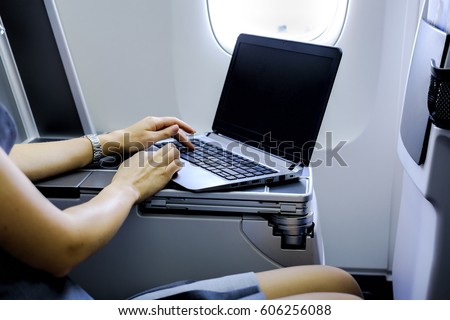 businesswoman working with laptop on airplane