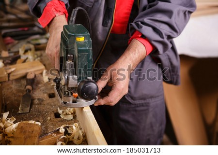 The carpenter hands when working with electric planer joinery
