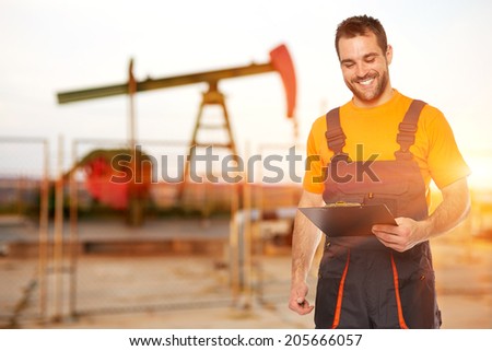 Refinery worker reads the data from the black plates, the background to the oil pump