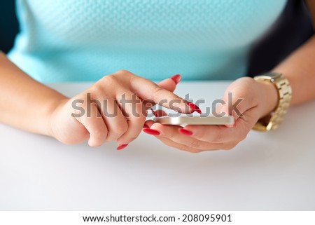 Female hand holding a cell phone and writing sms message