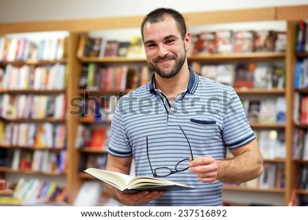 Portrait of a man in a polo shirt with glasses in a bookstore