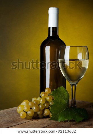 A glass full of wine and bottle on a yellow background