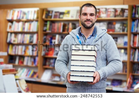 Young man hold books in the library