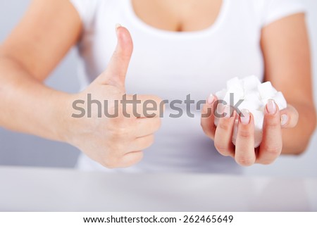 Woman is holding a handful of sugar cubes