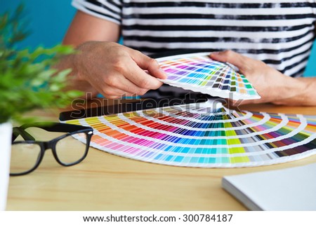 Graphic designer choosing a color from the palette