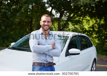Handsome man standing in front of car