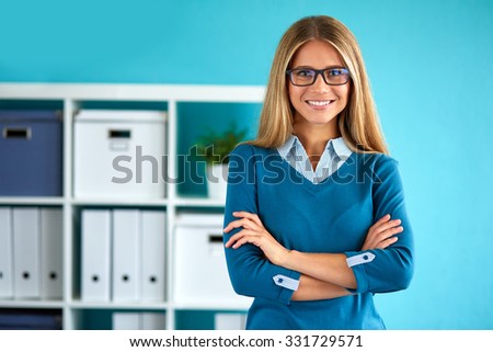 Young business woman standing in office with crossed arms