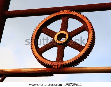 art of rusty and metallic gear wheel of old industry with blue sky