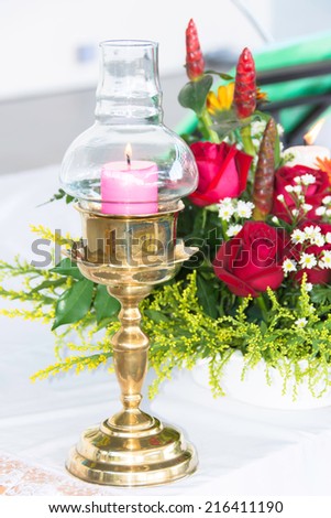 Candle lamp with a bouquet of flowers.