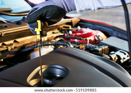 Checking engine oil level in modern car. Winter service for safe driving.
