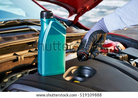 Filling engine oil in modern car. Winter service for safe driving.