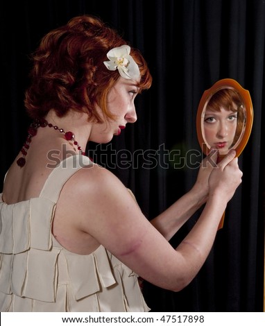 attractive red woman looking into mirror