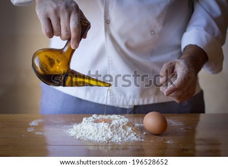 Chef making a cake on a wood table with olive oil