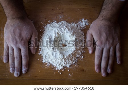 Hands and flour on a wood table