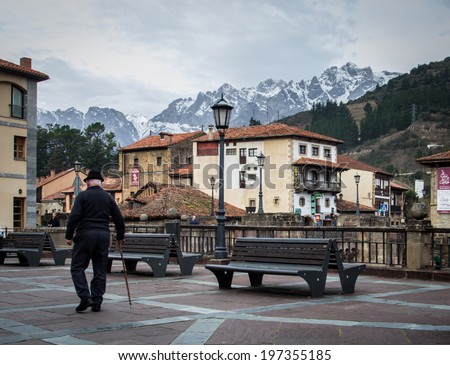 Old man in a village with snowy mountains