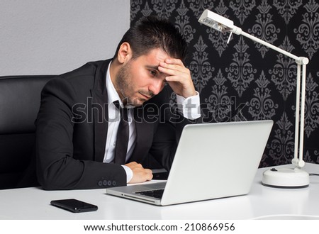Tired businessman with his hand on the head working in the office