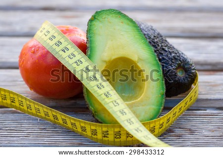 Fresh vegetables with a tape measure on a wooden background
